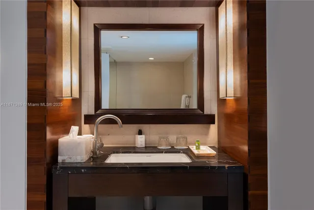 a bathroom with a granite countertop sink a toilet a mirror and shower