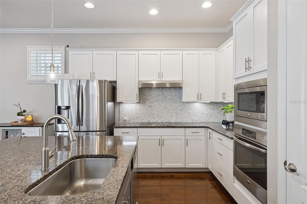 1565 Castile Street Celebration, FL 34747 - Photo 22 of 82 a kitchen with granite countertop a sink stainless steel appliances and cabinets
