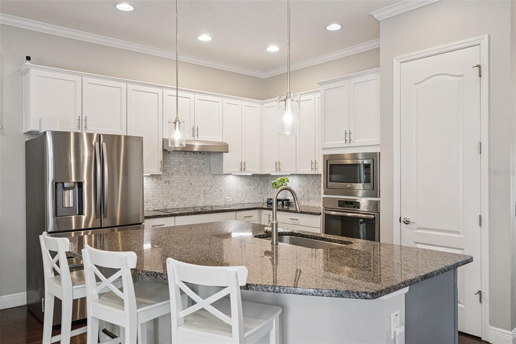 1565 Castile Street Celebration, FL 34747 - Photo 24 of 82 a kitchen with stainless steel appliances granite countertop a sink refrigerator and cabinets