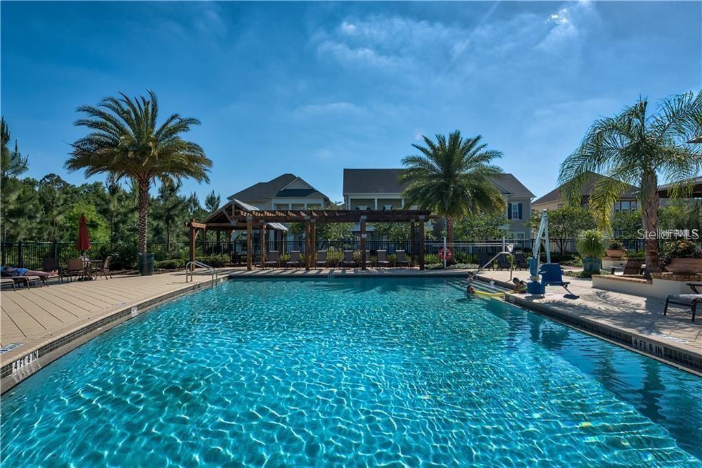 1565 Castile Street Celebration, FL 34747 - Photo 61 of 82 a view of a swimming pool with lawn chairs under an umbrella