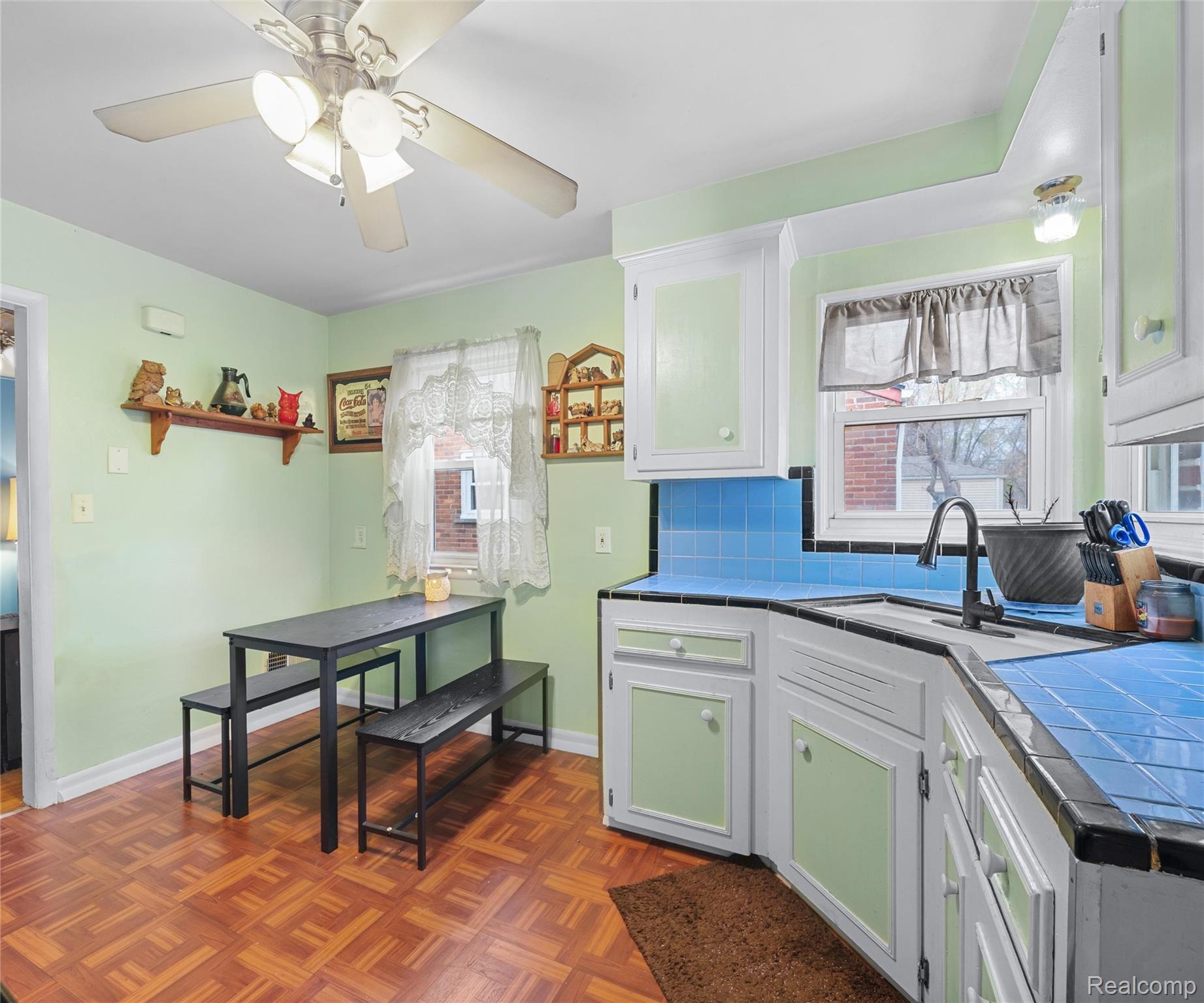 28940 Grandview Street Inkster, MI 48141 - Photo 22 of 41 Kitchen featuring tile countertops, white cabinetry, backsplash, and a ceiling fan