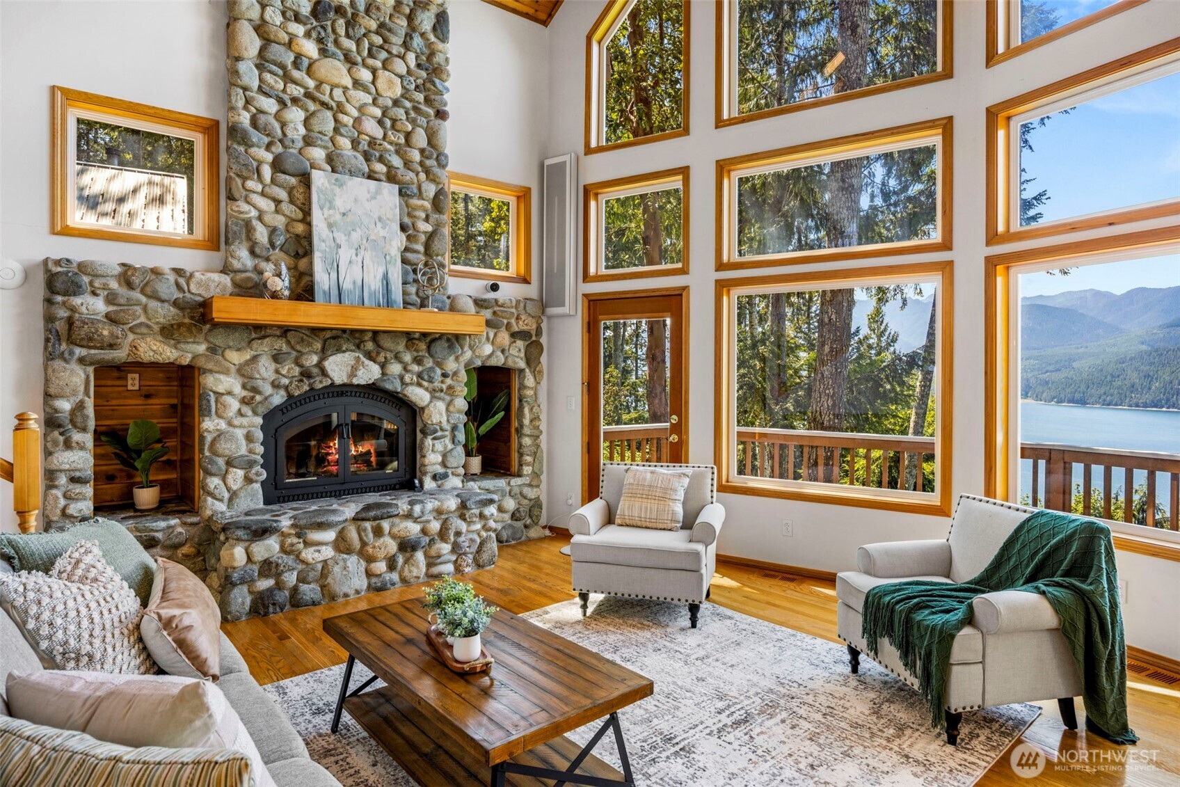 19736 Northwest Stavis Bay Road Seabeck, WA 98380 - Photo 6 of 39 a living room with furniture a floor to ceiling window and a fireplace