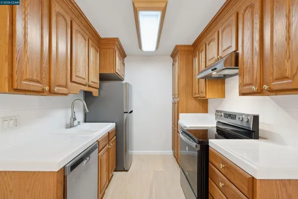 a kitchen with stainless steel appliances a stove a sink and a refrigerator