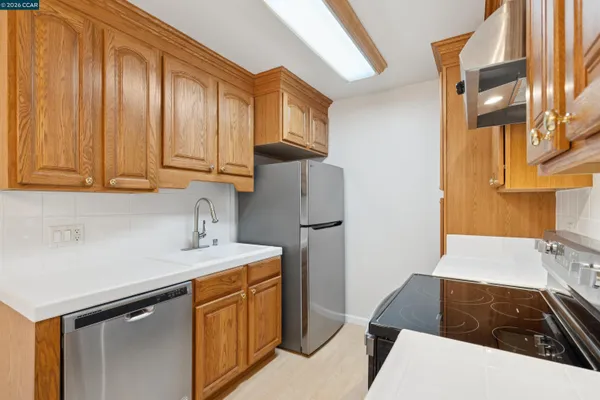 a kitchen with stainless steel appliances a stove a sink and a refrigerator
