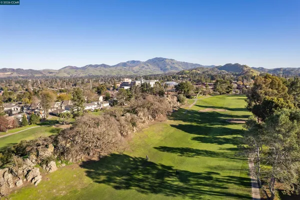 an aerial view of residential house with parking and mountain view
