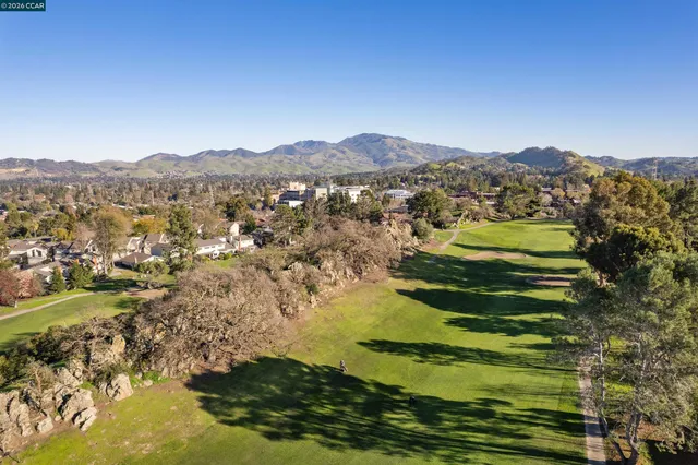 an aerial view of residential house with parking and mountain view