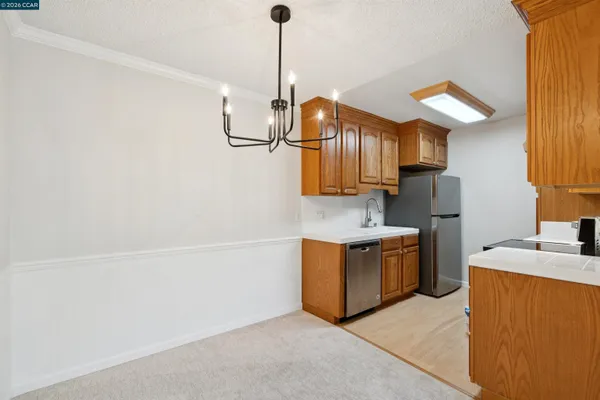 a kitchen with stainless steel appliances granite countertop a sink dishwasher a stove and a refrigerator