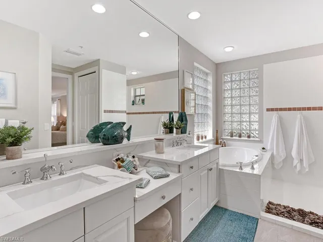a bathroom with a double vanity sink a mirror and a bathtub