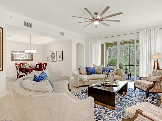 a living room with furniture a table and a large window