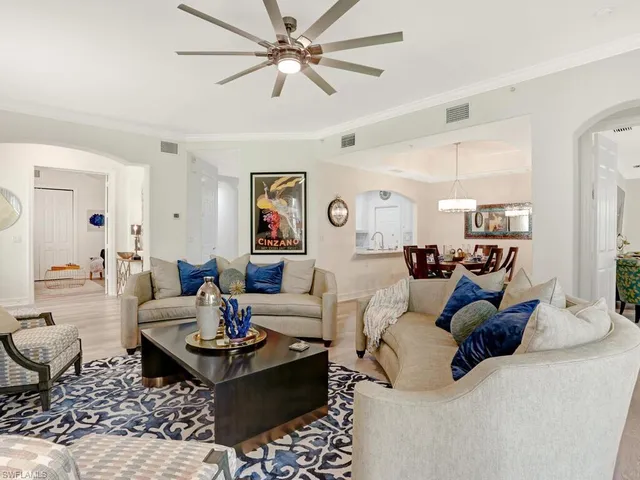a living room with lots of furniture and view of kitchen