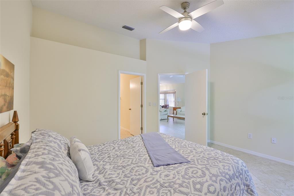 2431 Nantucket Harbor Loop, Unit 61 Sun City Center, FL 33573 - Photo 15 of 37 a bedroom with a bed and a chandelier