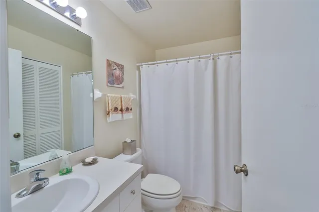 a bathroom with a sink a toilet and shower curtain