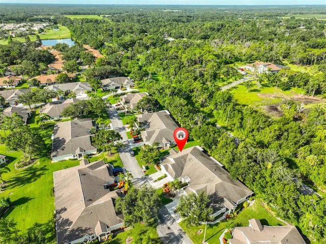 an aerial view of residential houses with outdoor space and trees all around