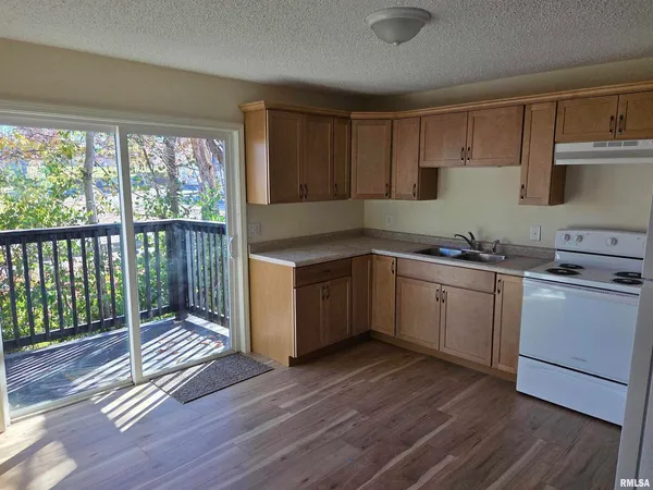 a kitchen with a sink wooden floor and a stove