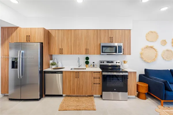 a kitchen with stainless steel appliances granite countertop a refrigerator stove top oven