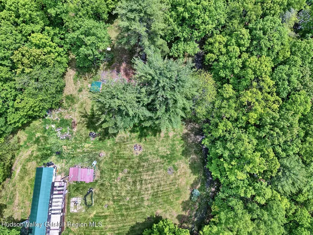 an aerial view of residential house with outdoor space and trees all around