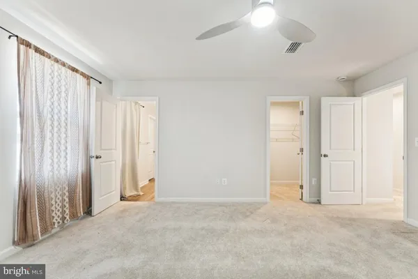 an empty room with closet and windows