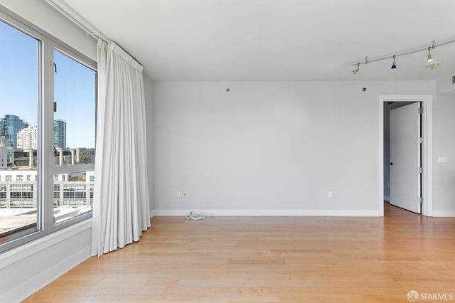a view of a big room with wooden floor kitchen view and windows