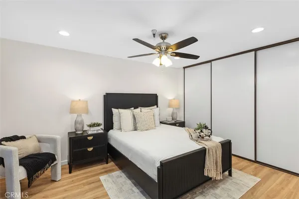 a large bedroom with a bed and wooden floor