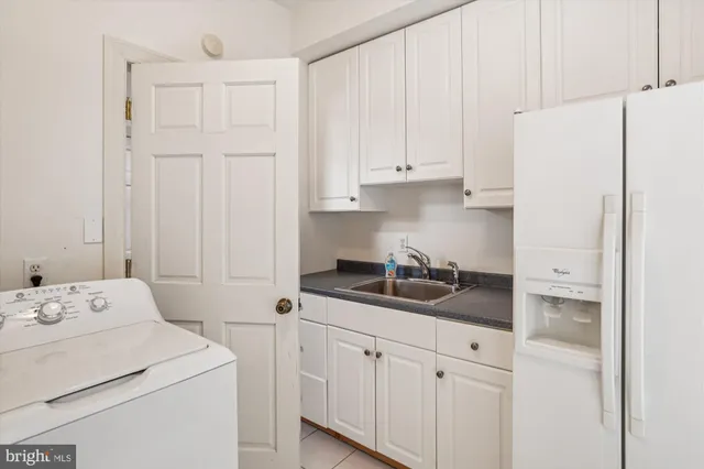 a kitchen with a sink dishwasher and white cabinets
