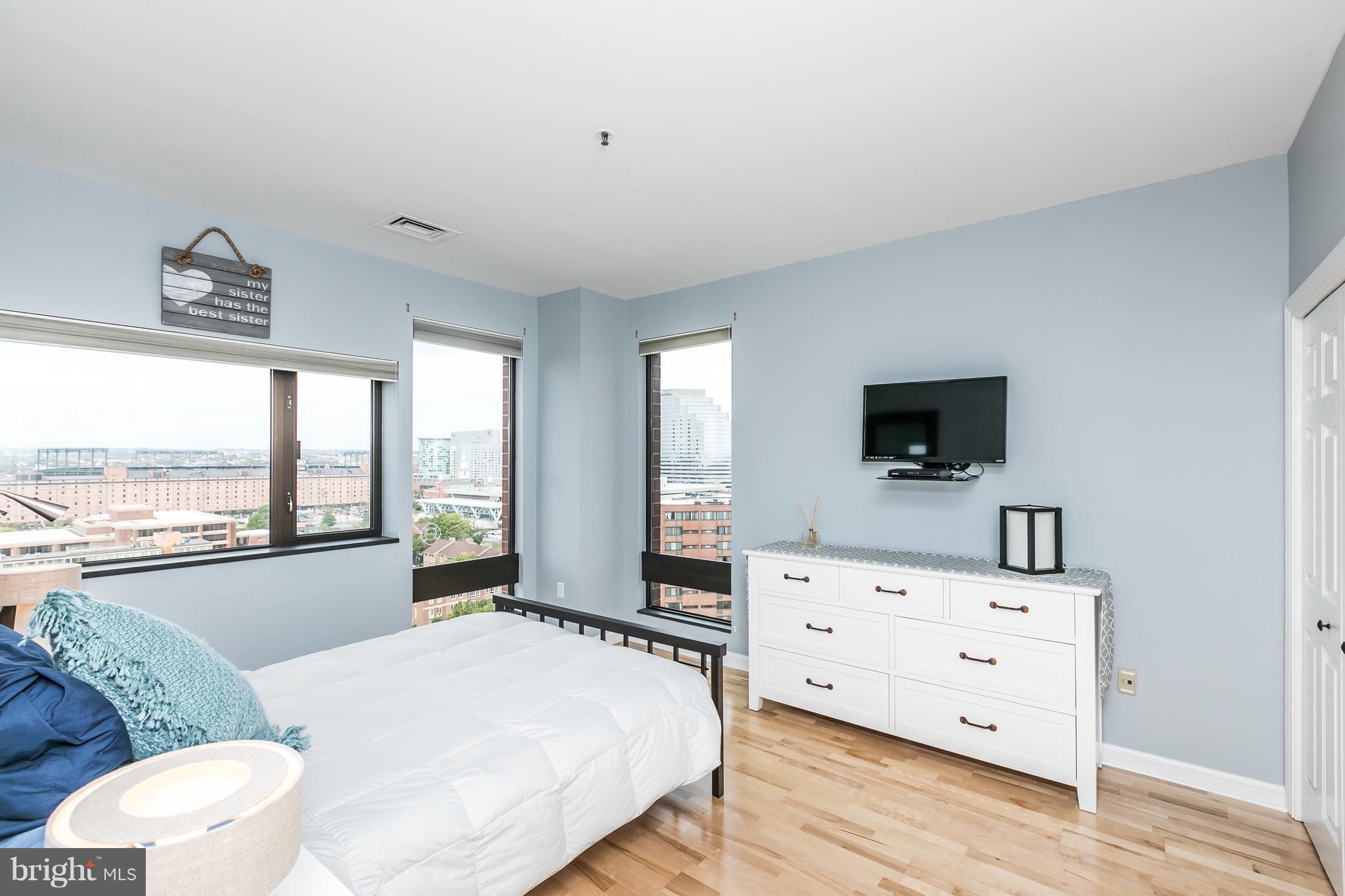 10 East Lee Street, Unit 1209 Baltimore, MD 21202 - Photo 23 of 38 a living room with furniture and a flat screen tv
