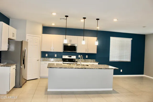 a large kitchen with kitchen island a sink stainless steel appliances and cabinets