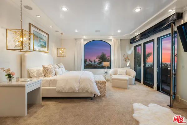 a spacious bedroom with a bed couch and a window