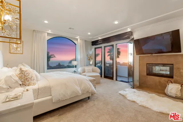 a bedroom with a large bed and a flat screen tv