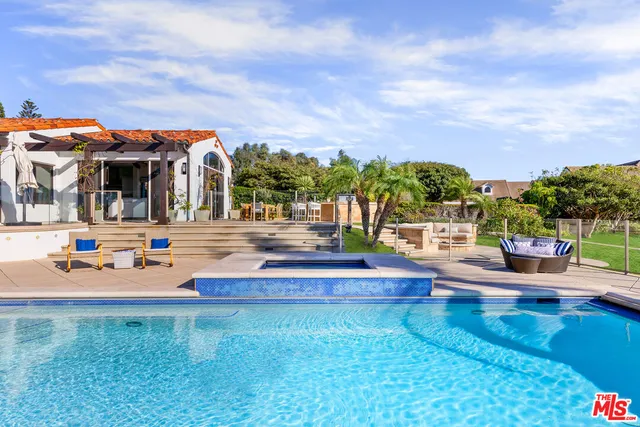 a view of yard with swimming pool and seating