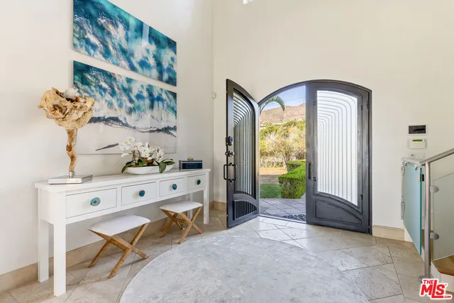a view of a hallway with paintings on the wall and a window