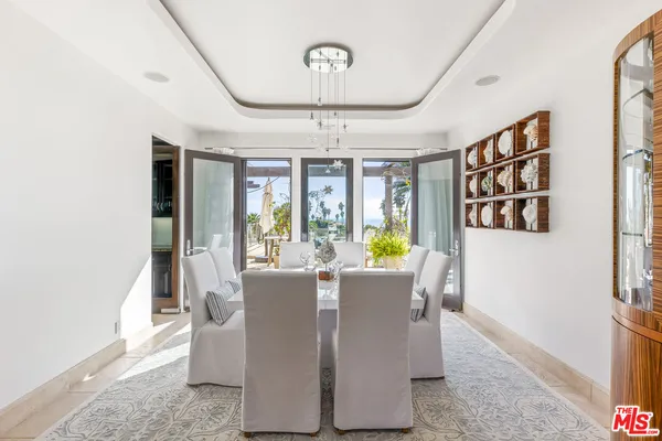 a dining room with furniture a chandelier and wooden floor