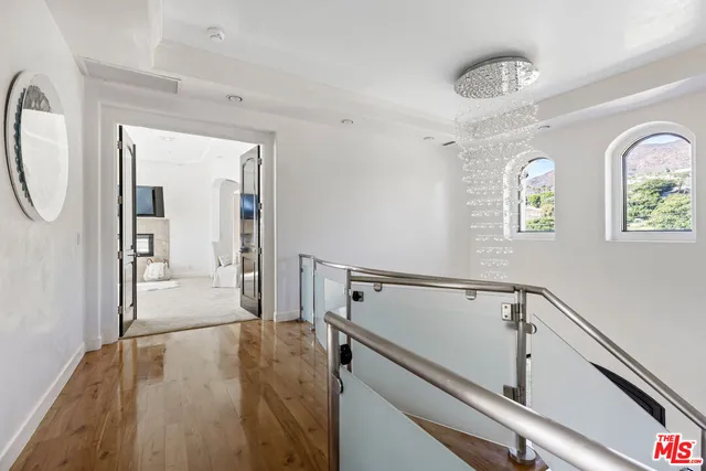 a view of a hallway with wooden floor and staircase