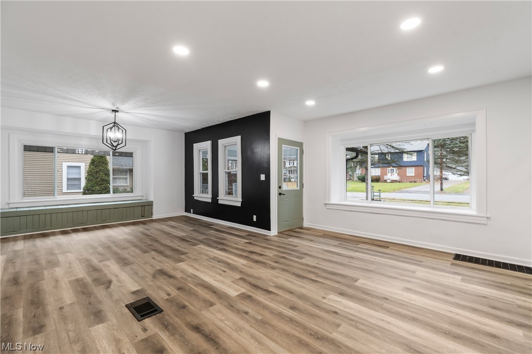 3561 Williamson Road Stow, OH 44224 - Photo 5 of 32 Unfurnished living room with light hardwood / wood-style floors, a wealth of natural light, and a notable chandelier