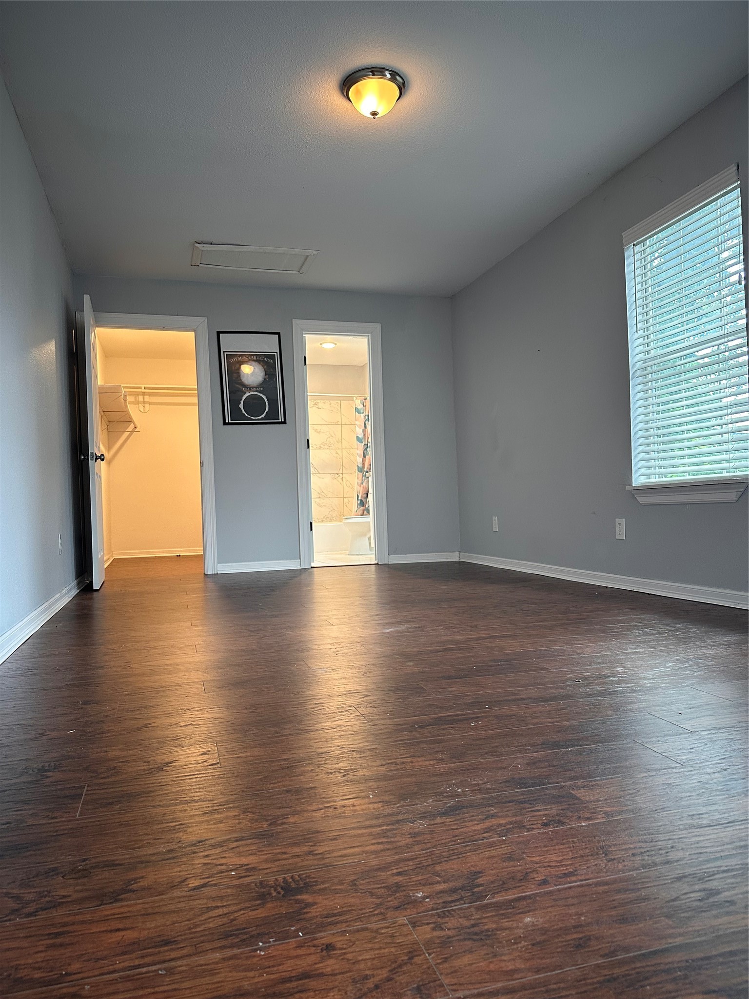 4802 Eppes Street Houston, TX 77021 - Photo 13 of 34 an empty room with wooden floor and windows with curtains