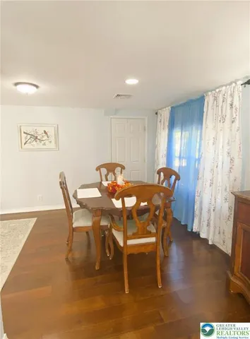 a kitchen with a dining table chairs refrigerator and microwave