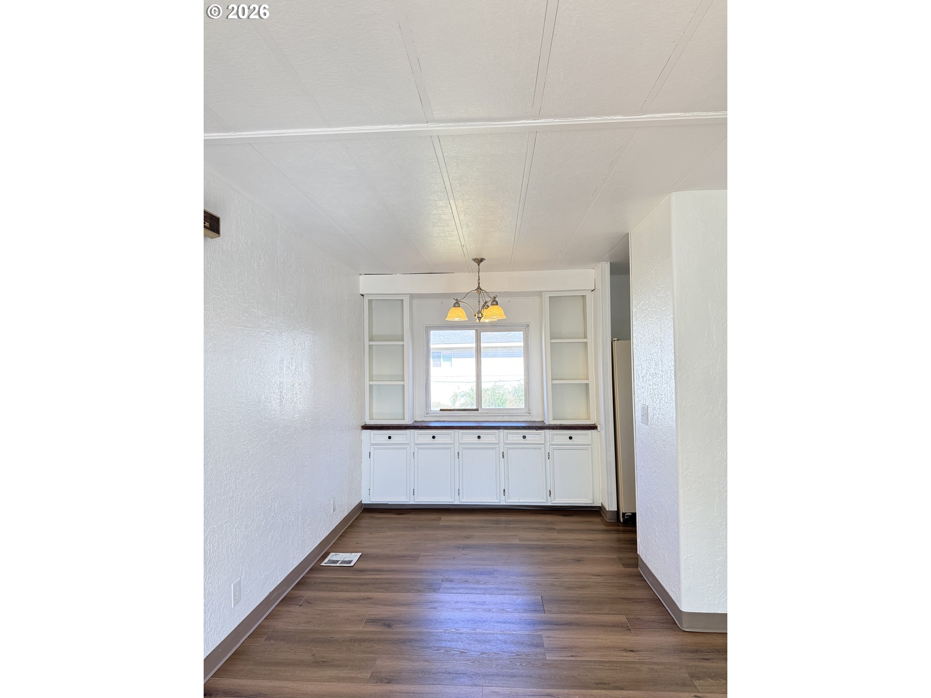 1330 West Sunland Avenue Hermiston, OR 97838 - Photo 4 of 23 a view of an empty room with wooden floor and a window