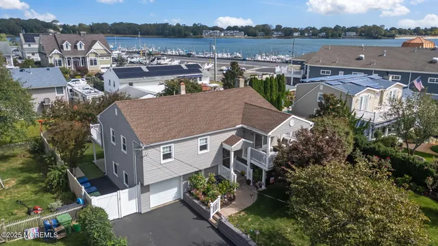 an aerial view of a house with a yard and lake view