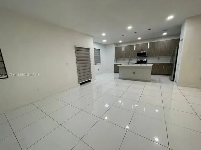 a large white kitchen with a sink and cabinets