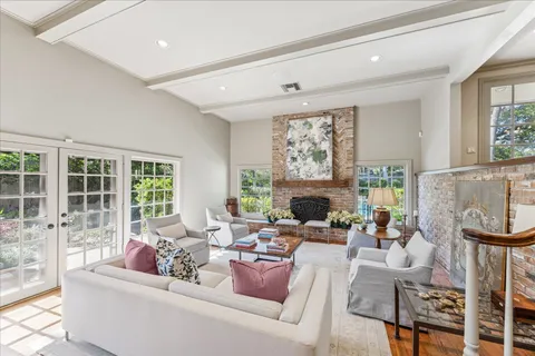 a living room with furniture large windows and a fireplace