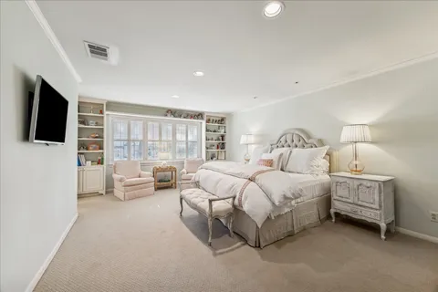 a spacious bedroom with a bed and a flat screen tv