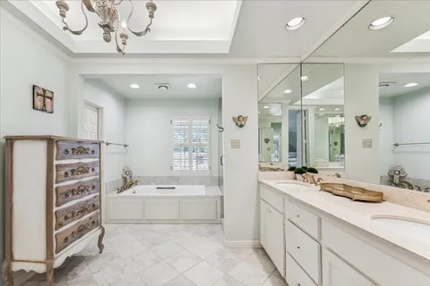 a bathroom with a double vanity sink mirror bathtub and shower