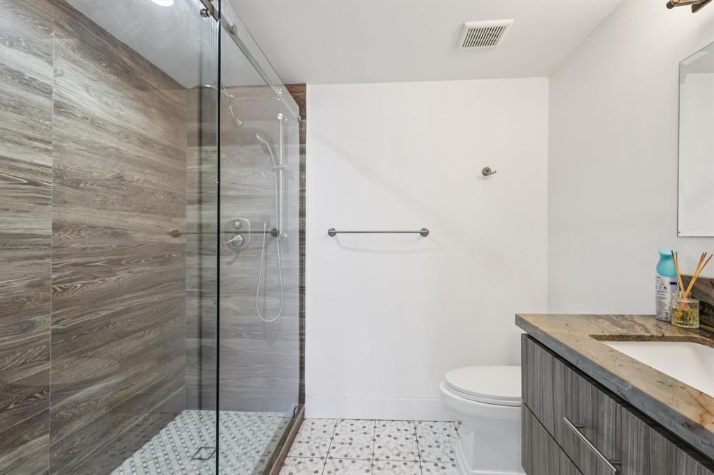 1660 Southwest 32nd Court Miami, FL 33145 - Photo 31 of 34 a bathroom with a granite countertop sink a toilet and shower