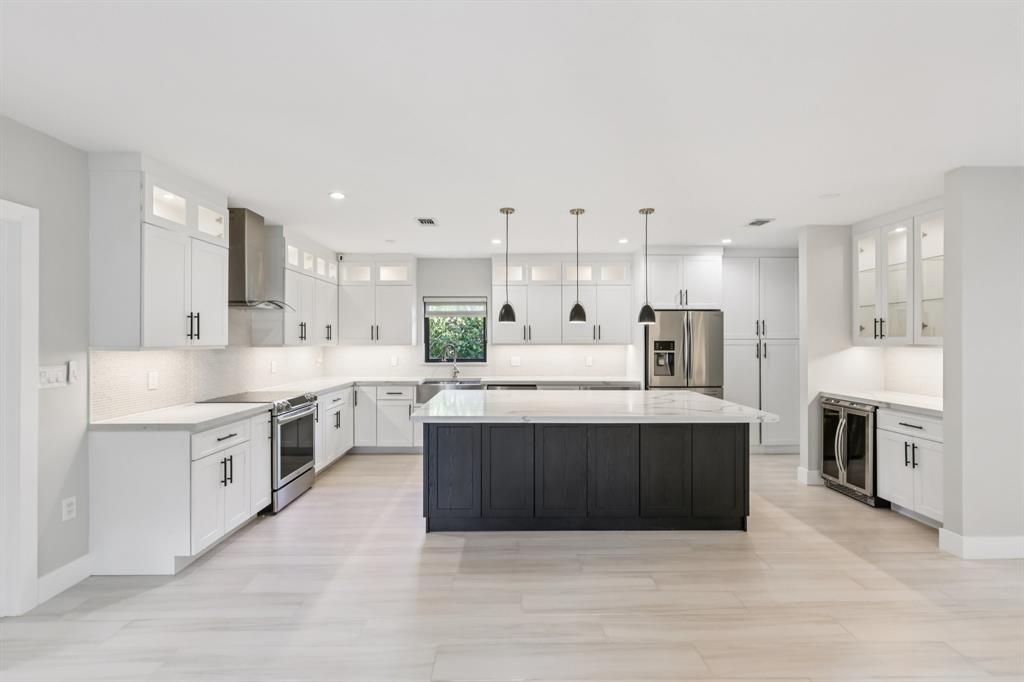 1660 Southwest 32nd Court Miami, FL 33145 - Photo 10 of 34 a large kitchen with a large counter top a sink stainless steel appliances and cabinets