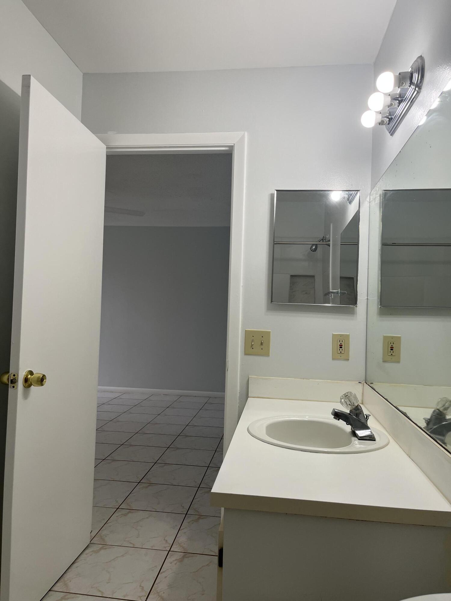 2103 Waterview Circle Palm Springs, FL 33461 - Photo 16 of 16 a bathroom with a sink and a mirror