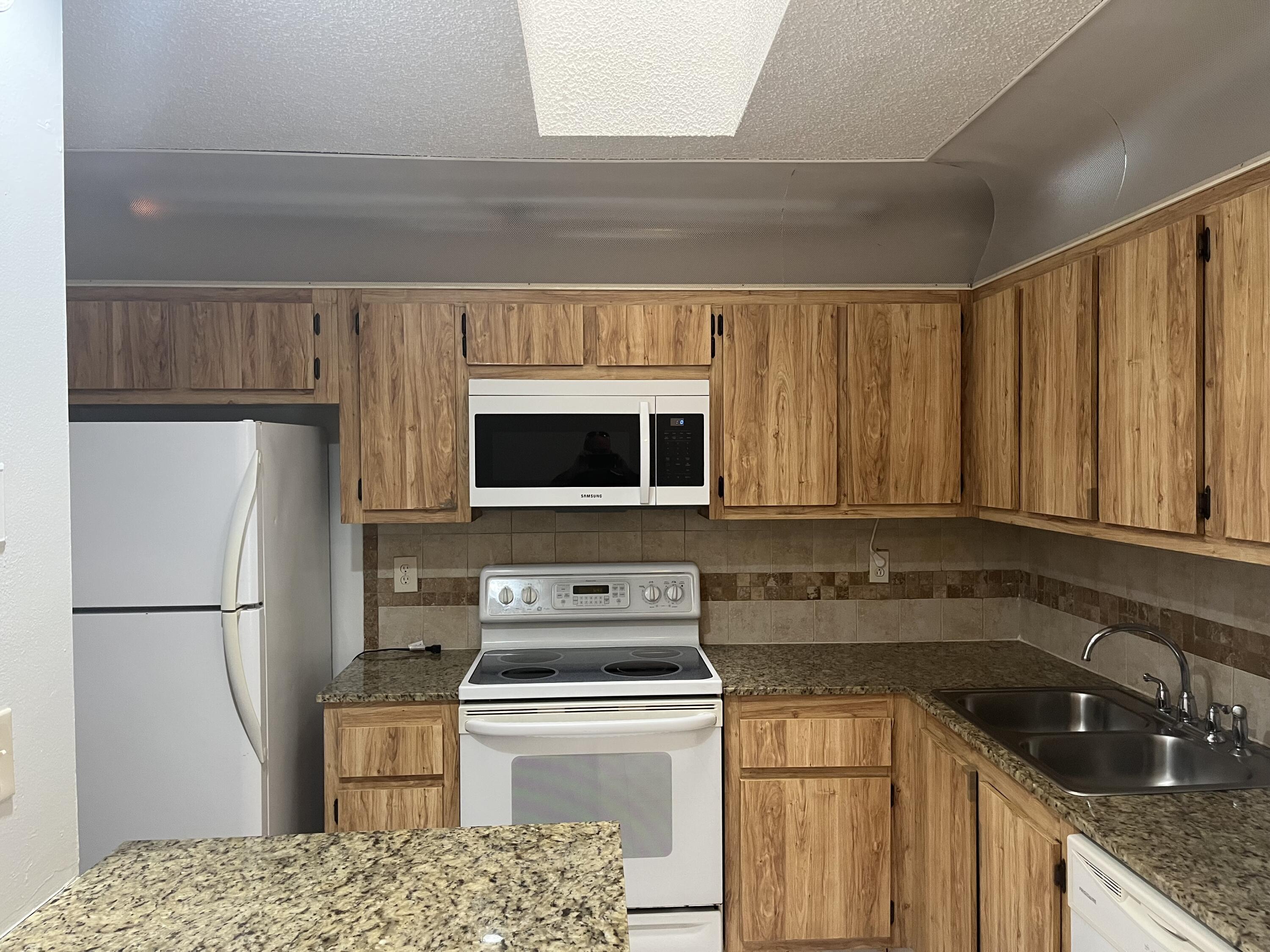 2103 Waterview Circle Palm Springs, FL 33461 - Photo 2 of 16 a kitchen with a sink a stove and refrigerator