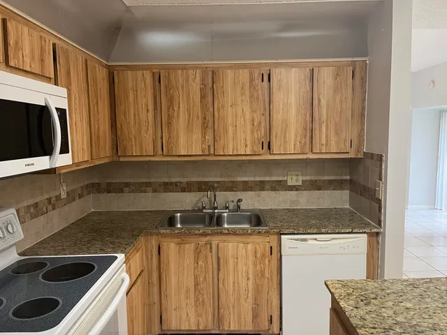 a kitchen with stainless steel appliances granite countertop a sink stove and microwave