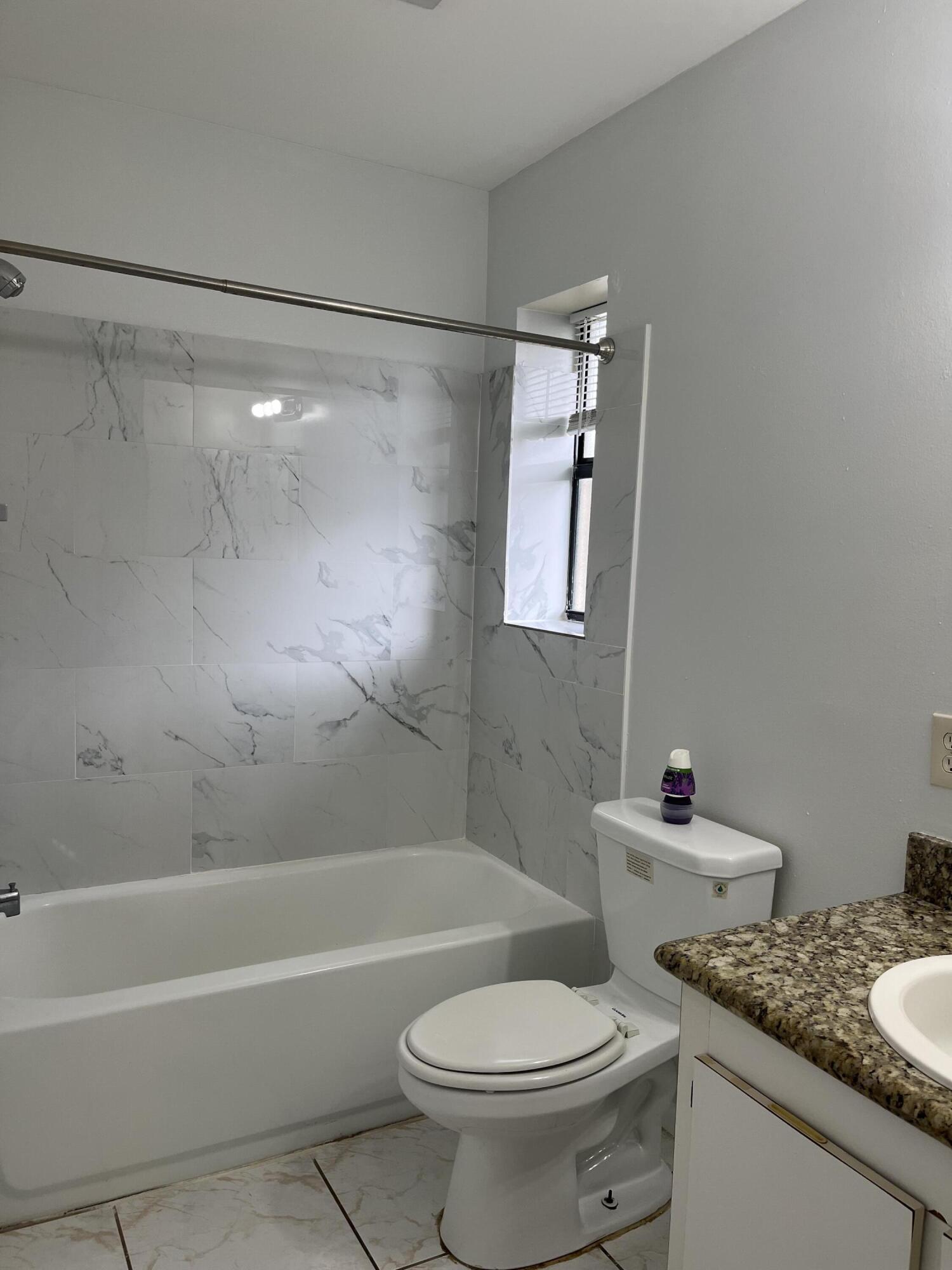 2103 Waterview Circle Palm Springs, FL 33461 - Photo 9 of 16 a bathroom with a granite countertop sink mirror toilet and bathtub
