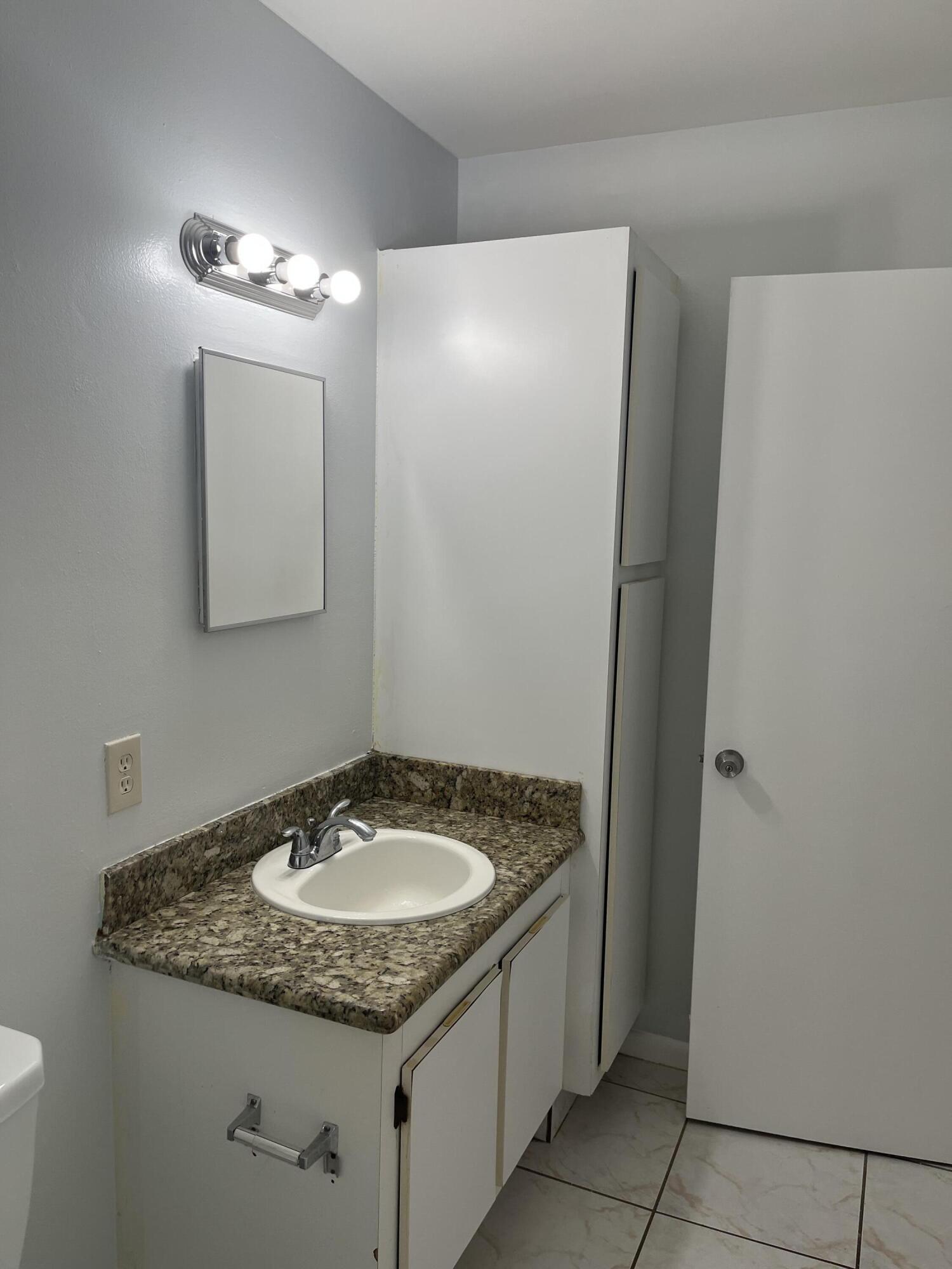 2103 Waterview Circle Palm Springs, FL 33461 - Photo 10 of 16 a bathroom with a granite countertop sink and a mirror