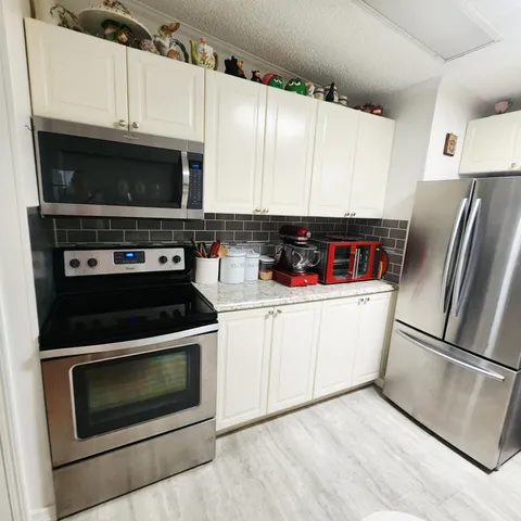 a kitchen with refrigerator and cabinets