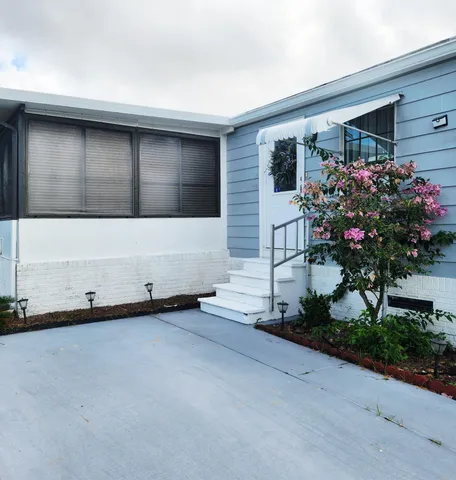 a living room with furniture kitchen view and a wooden floor